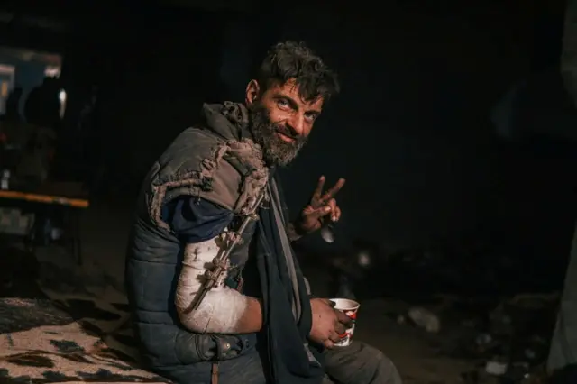 An injured Ukrainian service member sits at a field hospital inside the Azovstal metal works