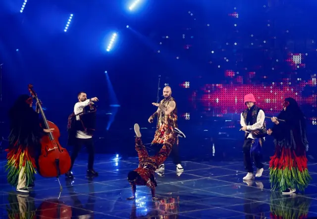 Performers from Ukraine's Kalush Orchestra sing and dance on stage