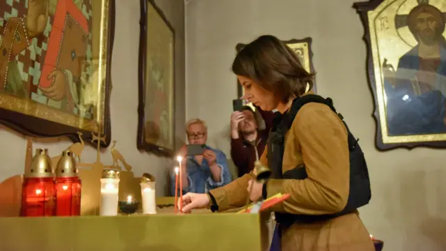 German Foreign Minister Annalena Baerbock lights a candle