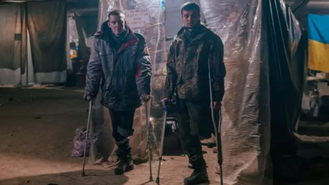 Injured Ukrainian service members use crutches at a field hospital inside a bunker of the Azovstal Iron and Steel Works in Mariupol, Ukraine