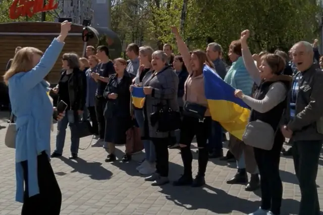 People shout slogans and hold Ukraine"s national flag during a protest