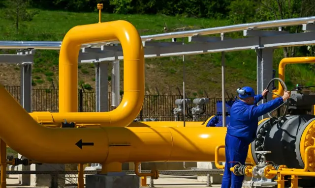 An employee turns a valve on a pipeline at the Bulgartransgaz gas compressor station in Ihtiman.