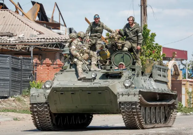 Russian servicemen are seen atop an armoured vehicle