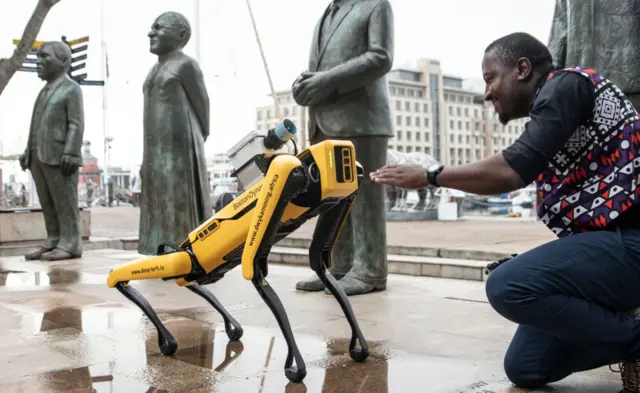 Spot and his handler Rethabile Leetlala from Dwyka mining services at V&A Waterfront on 11 May 2022 in Cape Town, South Africa.