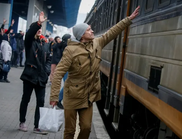 A man says goodbye to his relatives as an evacuation train from Kyiv to Lviv leaves