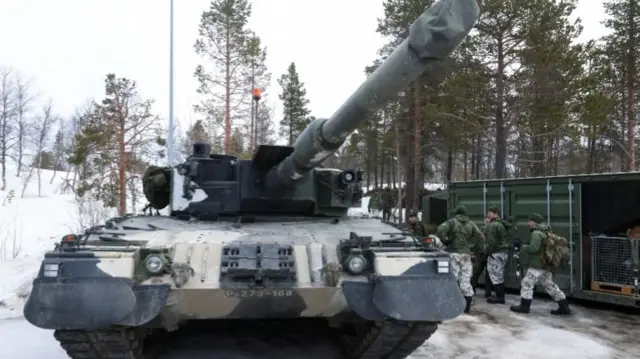 Finnish soldiers next to a tank during a military exercise called Cold Response 2022, Norway, March 2022