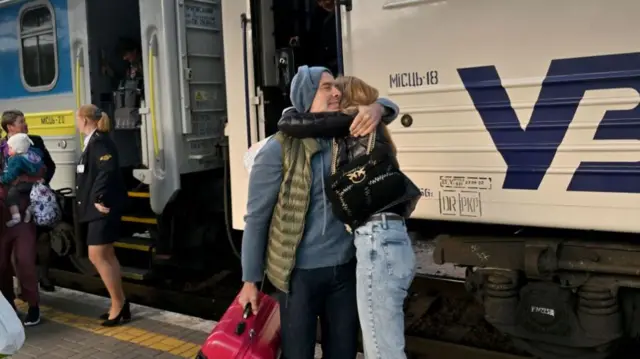 Man and woman hug at Kyiv railway station