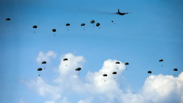 Italian paratroopers jump from an aircraft