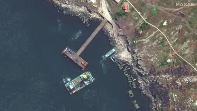 A satellite image shows a closer view of a barge, a Serna-class landing craft and a sunken Serna craft in Snake Island