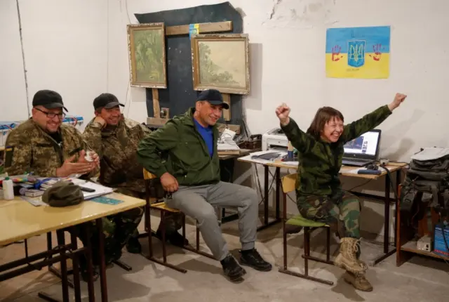 Ukrainian service members celebrate the winning of the Kalush Orchestra from Ukraine during the final of the 2022 Eurovision Song Contest, amid Russia"s attack on Ukraine, at their position in Kyiv region