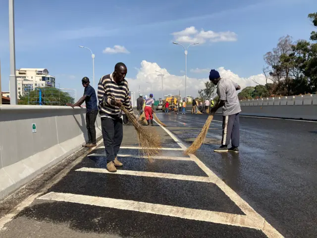 Workers put final touches in preparation for the opening an expressway in the Kenyan capitaln