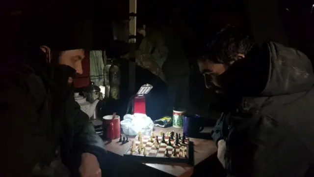 Service members of Mariupol's unit of the Ukrainian Sea Guard play inside a bunker of the Azovstal Iron and Steel Works