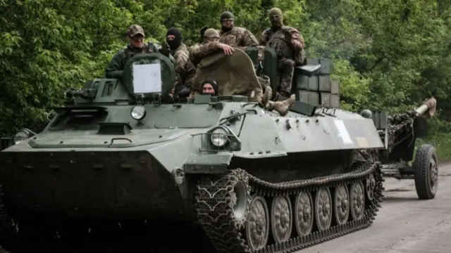 Ukrainian soldiers stand on a multipurpose light armoured towing vehicle near Bakhmut, eastern Ukraine, on May 15, 2022