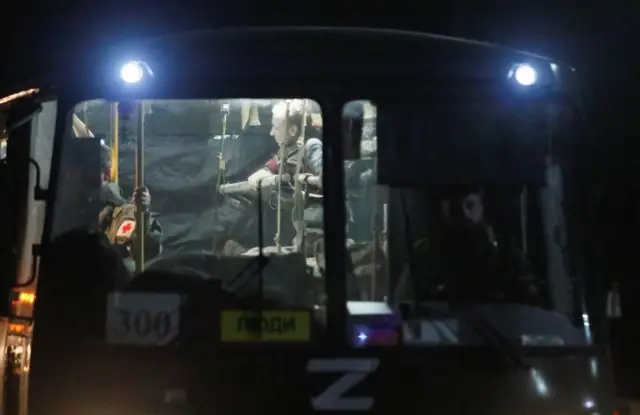 A bus carrying wounded service members of Ukrainian forces from the besieged Azovstal steelworks in Mariupol drives under escort of the pro-Russian military upon arrival in Novoazovsk, Ukraine, on 16 May 2022