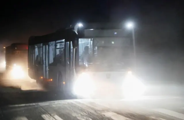 Buses carrying service members of Ukrainian forces from the besieged Azovstal steelworks drive away under escort of the pro-Russian military in Mariupol, Ukraine, on 16 May 2022