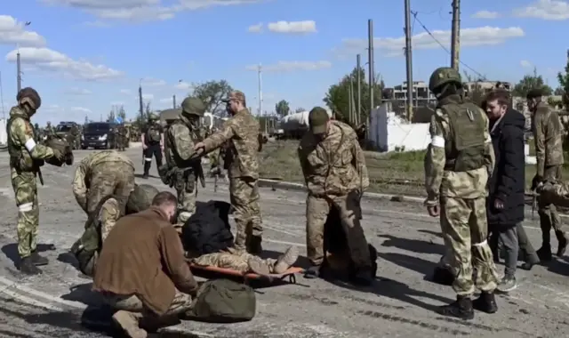 An injured soldier lies on a stretcher