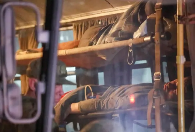 A bus carrying wounded service members of Ukrainian forces from the besieged Azovstal steelworks in Mariupol drives under escort of the pro-Russian military upon arrival in Novoazovsk, Ukraine, on 16 May 2022