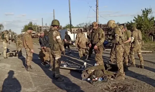 A soldier lies on the floor as pro-Russian troops search Ukrainian defenders