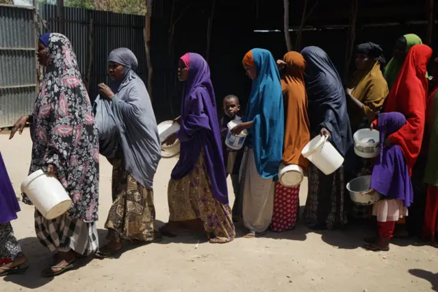 Recently arrived internally displaced women and children wait in a 'wet-food' line at a World Food Program centre in Mogadishu, Somalia in 2017