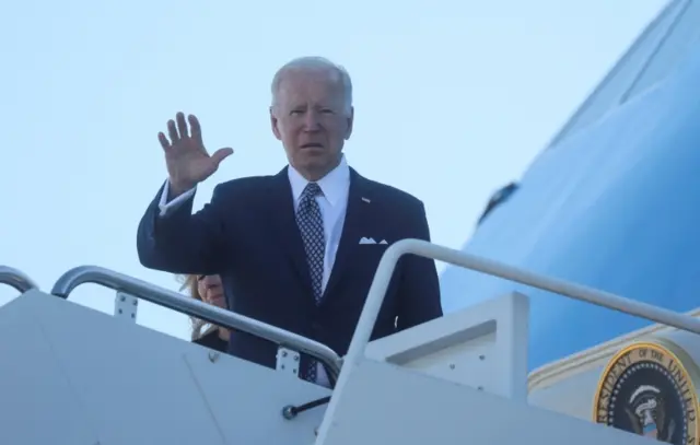 President Joe Biden waves while boarding Air Force One