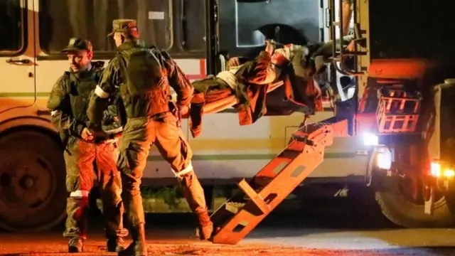 A picture purportedly showing a wounded Ukrainian soldiers from the besieged Azovstal steelworks in Mariupol is transported on a stretcher out of a bus in Novoazovsk, a town held by Russian-backed rebels. Photo: 16 May 2022