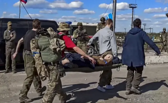 Another wounded fighter is taken away on a stretcher