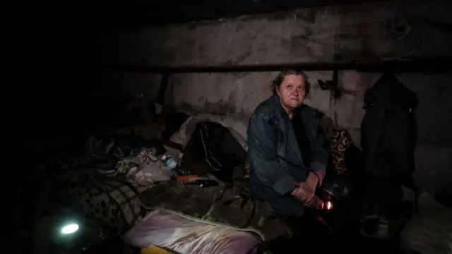 A Ukrainian woman in the basement of a school in Lysychansk where she has lived for over two months