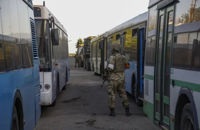 Self-proclaimed Donetsk People's Republic (DPR) militia guards buses readied for Ukrainian servicemen that are being evacuated from the besieged Azovstal steel plant in Mariupol, Ukraine, 17 May 2022.