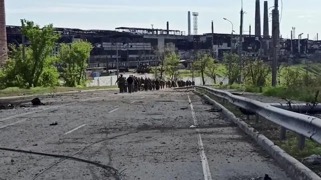 A picture released by the Russian Defence Ministry which it claims show Ukrainian soldiers who have surrendered at the Azovstal steelworks walking away