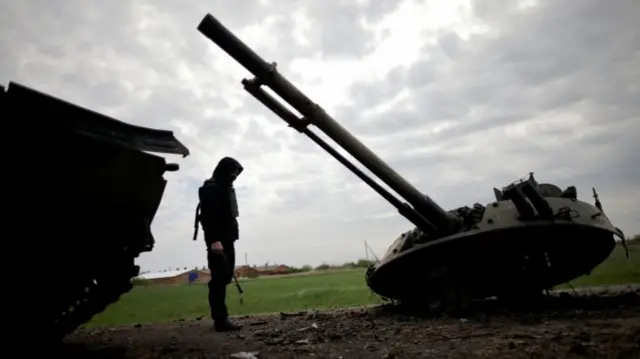 A Ukrainian serviceman looks at a destroyed Russian armoured vehicle,  Zaporizhzhia region, 30 April