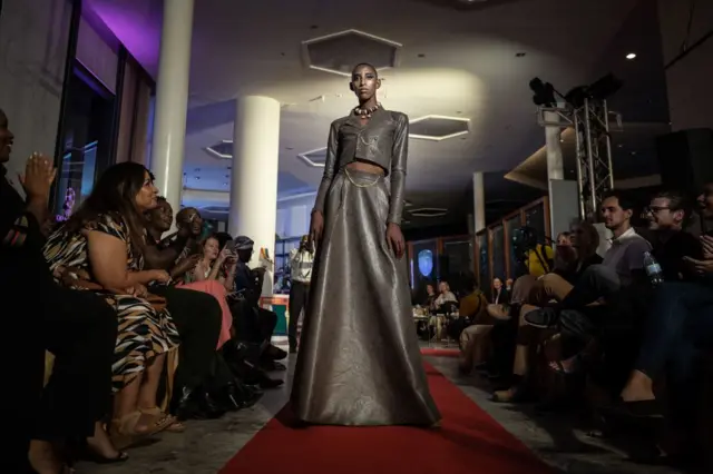 rince, a Rwandan model wearing Karssh Collections, walks on the runway during the Isano fashion show at Century Park, Kigali, Rwanda on May 17, 2022.