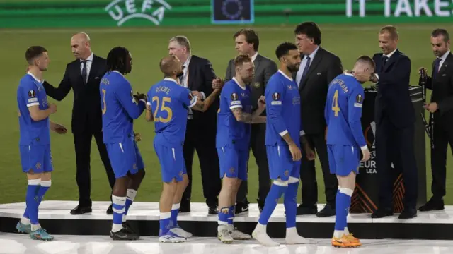 Crestfallen Rangers players collect the medal they didn't want to feel the weight of around their neck