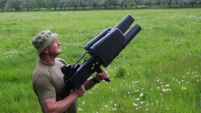 A Ukrainian soldier displays an anti-drone rifle in Kyiv