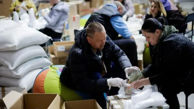 Ukrainian volunteers prepare to deliver food inside a complex set up as a shelter in Zaporizhzhya