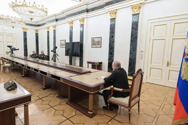 Russian President Vladimir Putin meets with his military officials