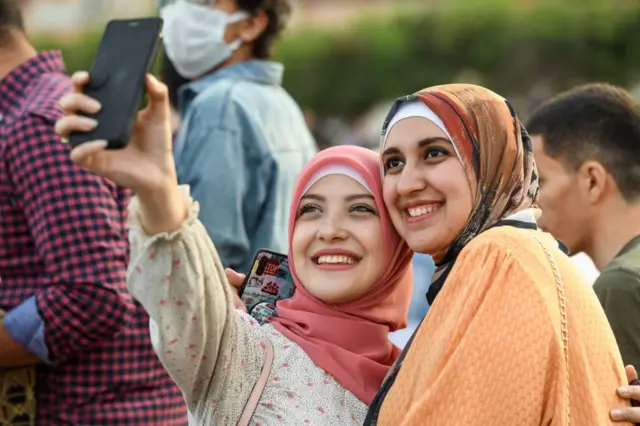 Worshipppers take a selfie as Muslims gather on the first day of Eid al-Fitr, which marks the end of the holy fasting month of Ramadan in the Heliopolis neighbourhood, in the Egyptian capital Cairo, on May 2, 2022.