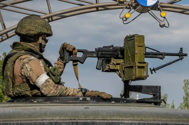 A Russian serviceman holding a mounted weapon