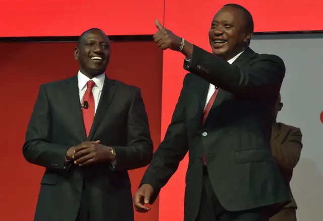 Kenya's President Uhuru Kenyatta (R), flanked by deputy president William Ruto, gestures during the unveiling of the Jubilee Party's manifesto on June 26, 2017 in Nairobi