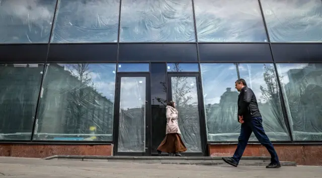 People walk past a closed business in Moscow