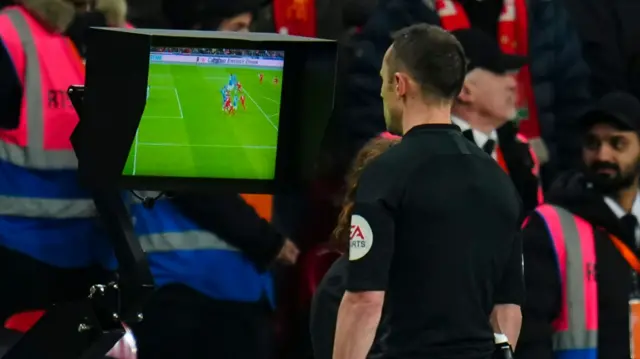 Stuart Attwell looks at the VAR screen to assess a decision