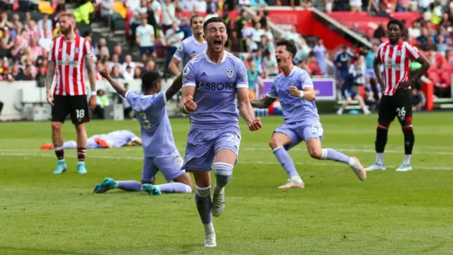 Jack Harrison (centre) celebrates