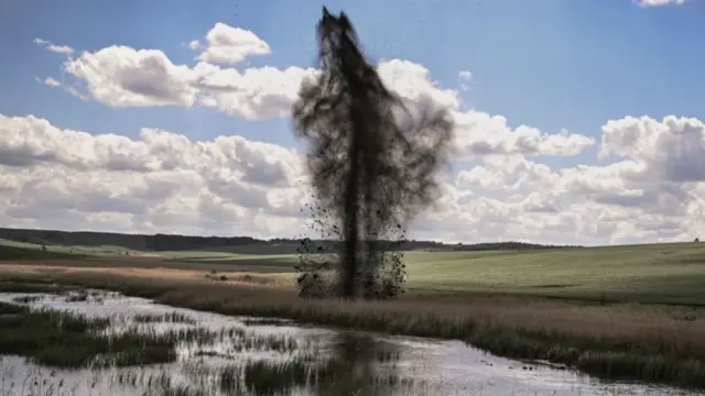 A mortar explodes next to the road leading to the city of Lysychansk in the eastern Ukrainian region of Donbas