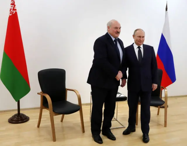 Putin (R) shakes hands with Lukashenko during talks last month