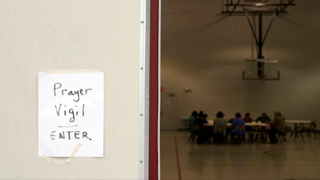 People attending a vigil pray for the victims of the school shooting