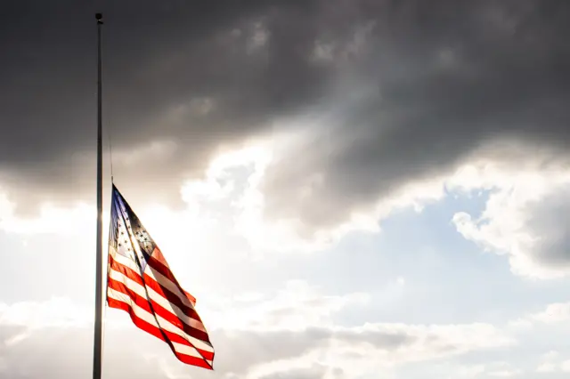 US flag flying at half-mast (stock photo)