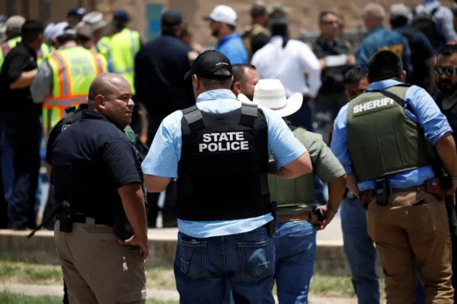 Law enforcement personnel guard the scene of a suspected shooting near Robb Elementary School in Uvalde,