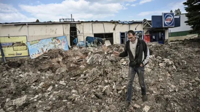 A man walks in front of a destroyed supermarket after a strike in the city of Soledar at the eastern Ukranian region of Donbas