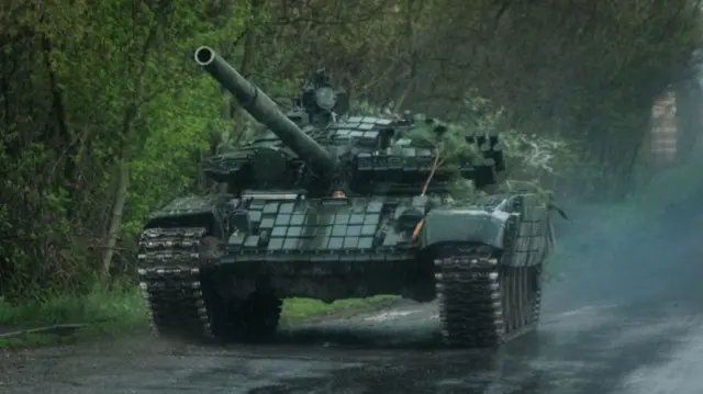 A T-72 tank rolling down a wet road near Lyman, eastern Ukraine