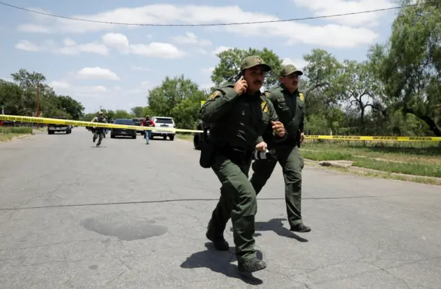 Law enforcement personnel run away from the scene of a suspected shooting near Robb Elementary School in Uvalde, Texas, U.S. May 24, 2022.