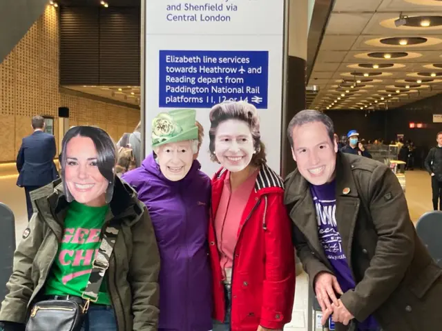 People wearing masks of the Royal Family